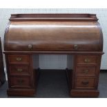 A Victorian mahogany roll top desk, with fitted interior, over six pedestal drawers,