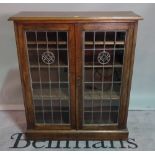 An early 20th century oak glazed two door side cabinet on plinth base, 104cm wide x 120cm high.