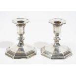 A pair of silver candlesticks, each raised on an octagonal stepped base (loaded), hallmarks rubbed,