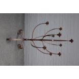 A large modern wrought iron nine branch floor standing candelabra, on three scroll supports,
