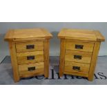 A pair of modern oak three drawer bedside chests, 53cm wide x 62cm high.
