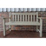A green painted teak garden bench, with slatted back and seat, 128cm wide x 82cm high.