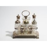 A silver eight bottle cruet frame, having an oval loop shaped handle, raised on four scrolled feet,