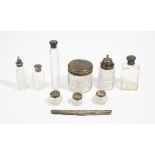 A silver twin handled trophy cup, nine various silver topped cut glass bottles and jars,