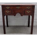 An 18th century oak lowboy, with three frieze drawers, on canted block supports,