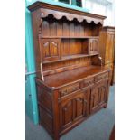 An 18th century style fruitwood dresser, the enclosed two tier plate rack, with a pair of cupboards,