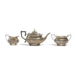 A silver three piece tea set, comprising; a teapot, a twin handled sugar bowl and a milk jug,