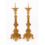 A pair of gilt metal pricket candlesticks, 20th century, resting on three lions paw feet, 63cm high.