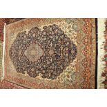 An Indian rug of Persian design, the dark indigo field with a pale medallion, ivory spandrels,