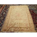 A Hereke silk rug, Turkish, the ivory field with a pale madder shaped medallion,