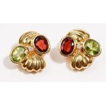A pair of yellow precious metal, diamond, green peridot and garnet set earclips Of abstract design,