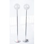 A pair of modern chrome floor standing lamps, with wire filled globular glass shades, 154cm high.