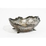 A silver bonbon basket, with scroll pierced decoration below a cast scrolling rim,