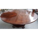 A large Regency style circular mahogany dining table, on turned column and paw feet,