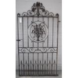 A wrought iron garden gate with arch crest and floral relief panel, 112cm wide including hinge,