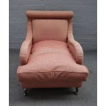 A late Victorian style library armchair, upholstered in pink, on turned legs and castors,