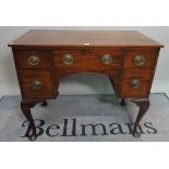 A Regency mahogany writing desk, with five drawers about the knee on cabriole pad supports,