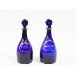 A near pair of blue glass club shaped decanters and stoppers, 19th/20th century,