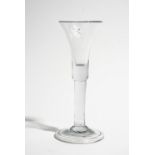 A plain stemmed wine glass, mid 18th century, the waisted bell bowl with solid base,