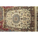 An Esfahan mat, Persian, the ivory field with a central indigo medallion,