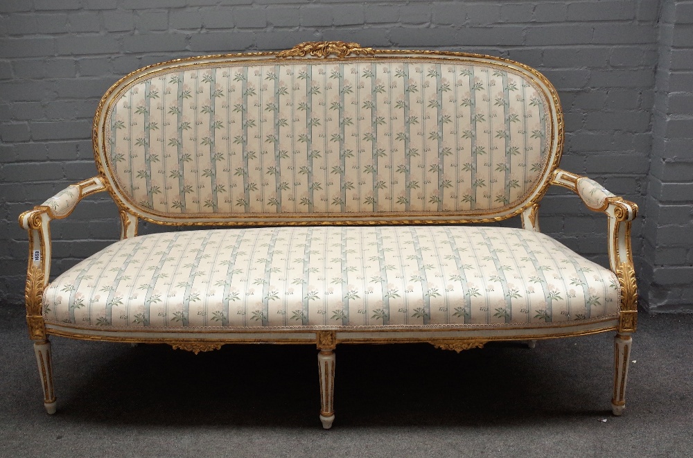 A Louis XVI style painted and gilt framed upholstered settee, 19th century, with ribbon mouldings,