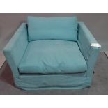A modern low armchair, with light blue upholstery, 119cm wide x 66cm high.