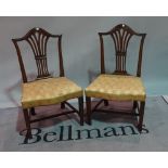 A pair of George III mahogany shield back dining chairs, on tapering square supports,