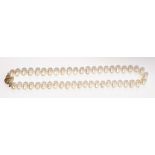 A single row baroque cultured pearl necklace Suspended from a diamond-set spherical gold clasp,