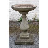 A weathered pre-cast bird bath, after the antique, on a baluster pillar, 68cm high x 45cm diameter.