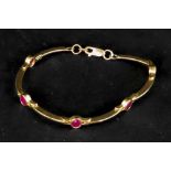 A 9ct gold and ruby set bracelet, the ov