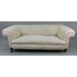 A Victorian upholstered Chesterfield settee, on turned mahogany legs with gilt metal feet,
