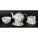 A Belleek shamrock pattern teapot, sugar bowl, teacup and saucer and a candle holder (5).