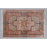 A modern silk rug, with a central flowerhead medallion, on an ivory ground, 100 x 69cm.