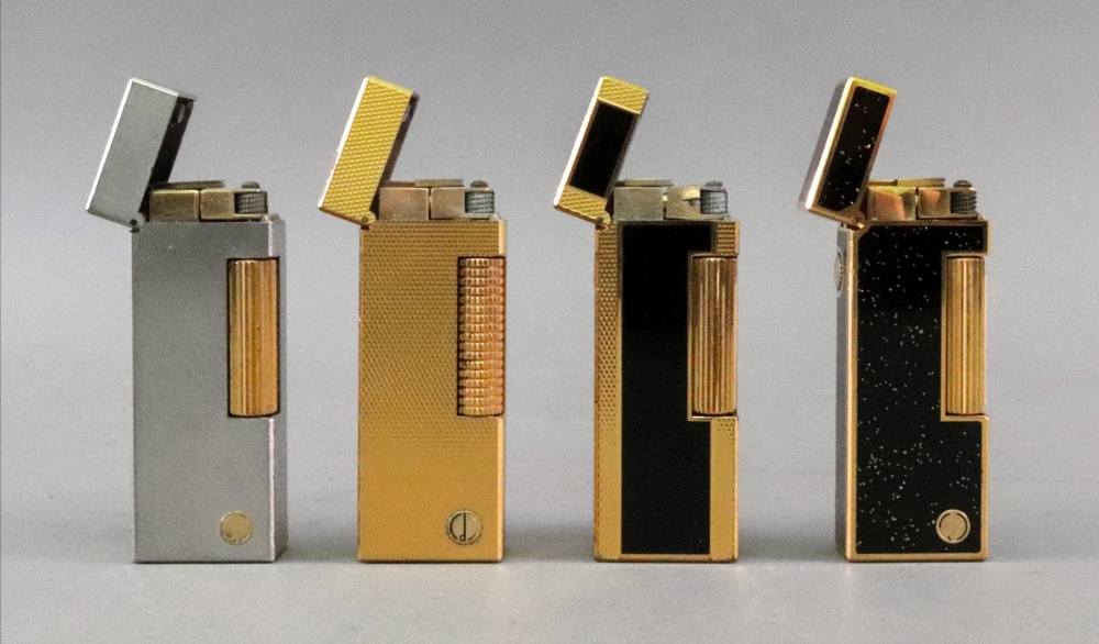 Four Alfred Dunhill lighters, one with brushed finish, one engine turned with repeated lozenges,