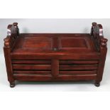 A Chinese curved rectangular low stool, 20th century, with slatted sides and compartment seat,