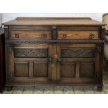 A reproduction late 17th century style carved oak low dresser, of panelled construction,