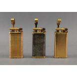 Three Alfred Dunhill lighters, of oval s