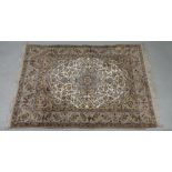 A modern Kashan rug, with a central medallion surrounded by flowering branches, on an ivory ground,