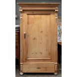 A Dutch waxed and carved pine wardrobe, circa 1880, enclosed by a panelled door with a drawer below,