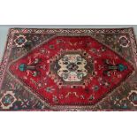 A modern Iranian rug, with a large central medallion surrounded by birds and flowers,