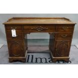 A late 19th century kneehole desk with three frieze drawers over cupboard doors on bracket feet,