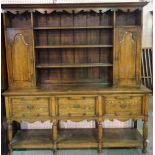 An 18th century style oak dresser with three tier plate rack flanked by arch doors over three