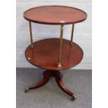 A George III mahogany and brass circular two tier dumb waiter, on three downswept supports,