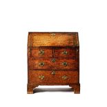 An oak bureau, mid 18th century, the hinged fall enclosing a fitted interior,