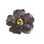 A gold, oxidised silver, citrine and amethyst set brooch of stylized flowerhead design,