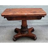 A Regency mahogany foldover card table, on carved and turned column and four scroll feet,