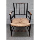 After 'William Morris', a Sussex style ebonised beech open armchair, with turned supports,