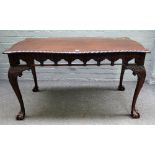 A mid 18th century style mahogany serpentine centre table with pierced and carved frieze on claw