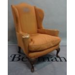 An 18th century style mahogany framed wingback armchair on cabriole supports,
