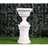 A white painted terracotta jardineire with cherub mask handles, on turned socles,
